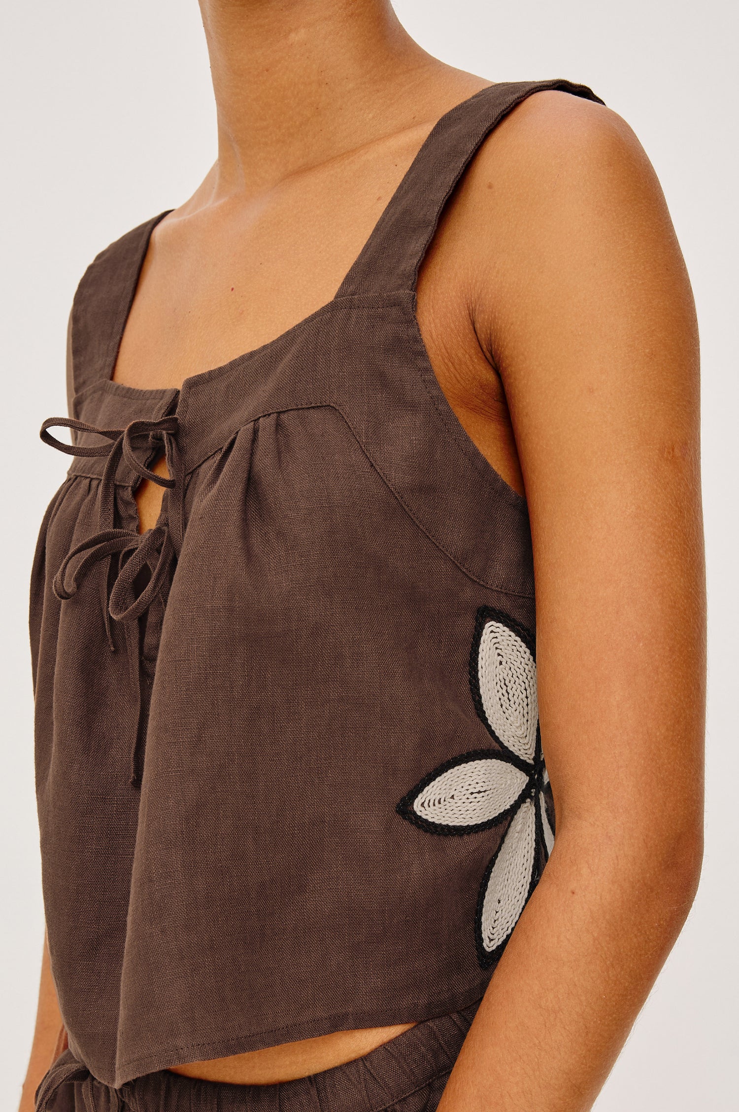 Calais Tank Top in Heavy Linen With Boxy, Loose Relaxed Cropped Fit, Wide Shoulder Straps, and V-Neckline With Adjustable Front Ties in Cocoa Floral Embroidery Colorway - Upper Body Front View Featured on Model