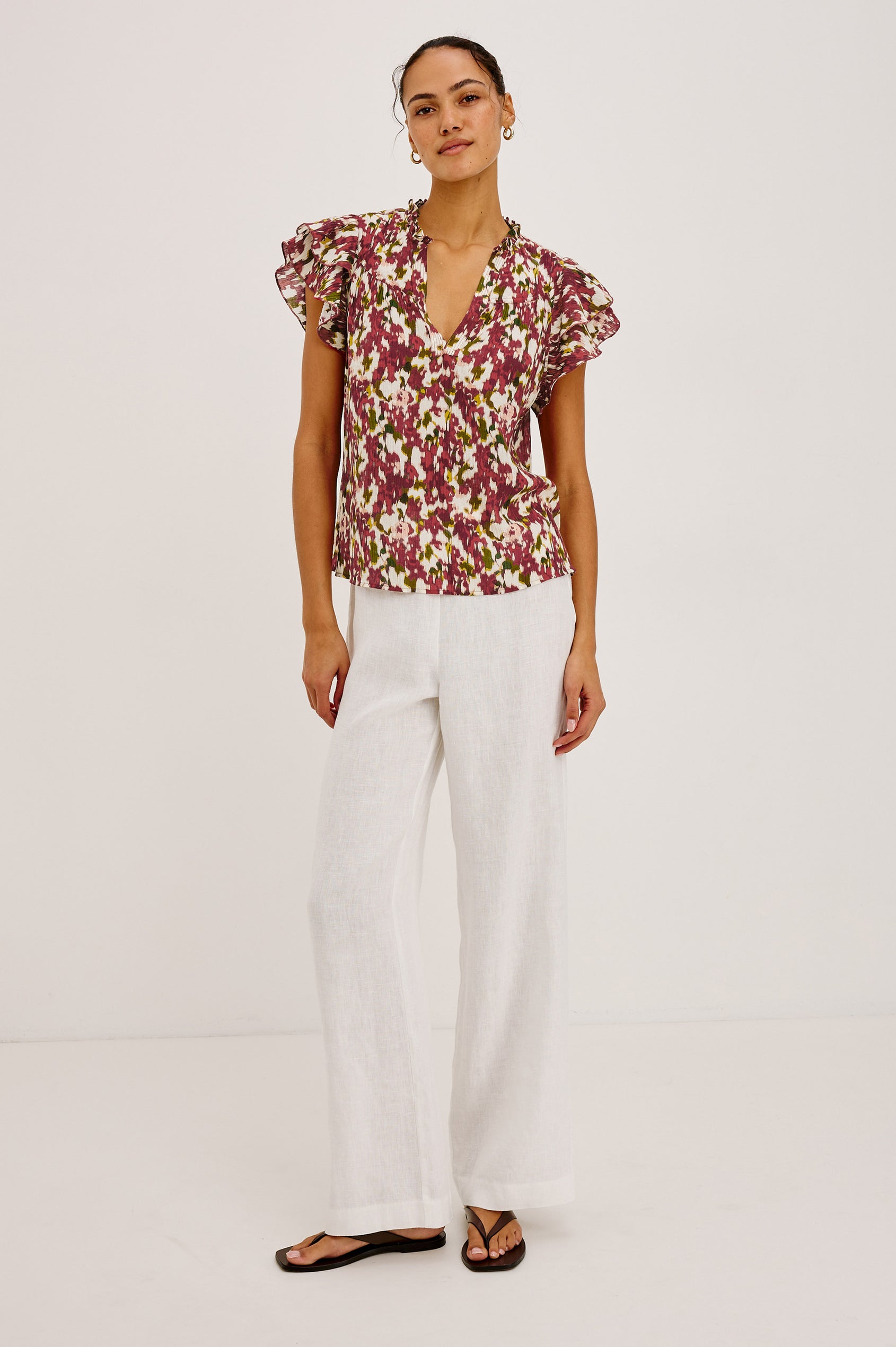 Calista Top in Textured Chiffon With Ruffle Trim Split V-Neckline, Layered Flutter Sleeves, and Relaxed Fit in Cardinal Floral Colorway - Full Body Front View Featured on Model