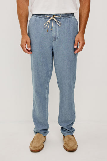 Callum Tapered Straight Leg Pant in Linen Twill With Adjustable Drawstring Waistband Ties in Medium Wash Indigo Colorway - Lower Body Front View Featured on Model