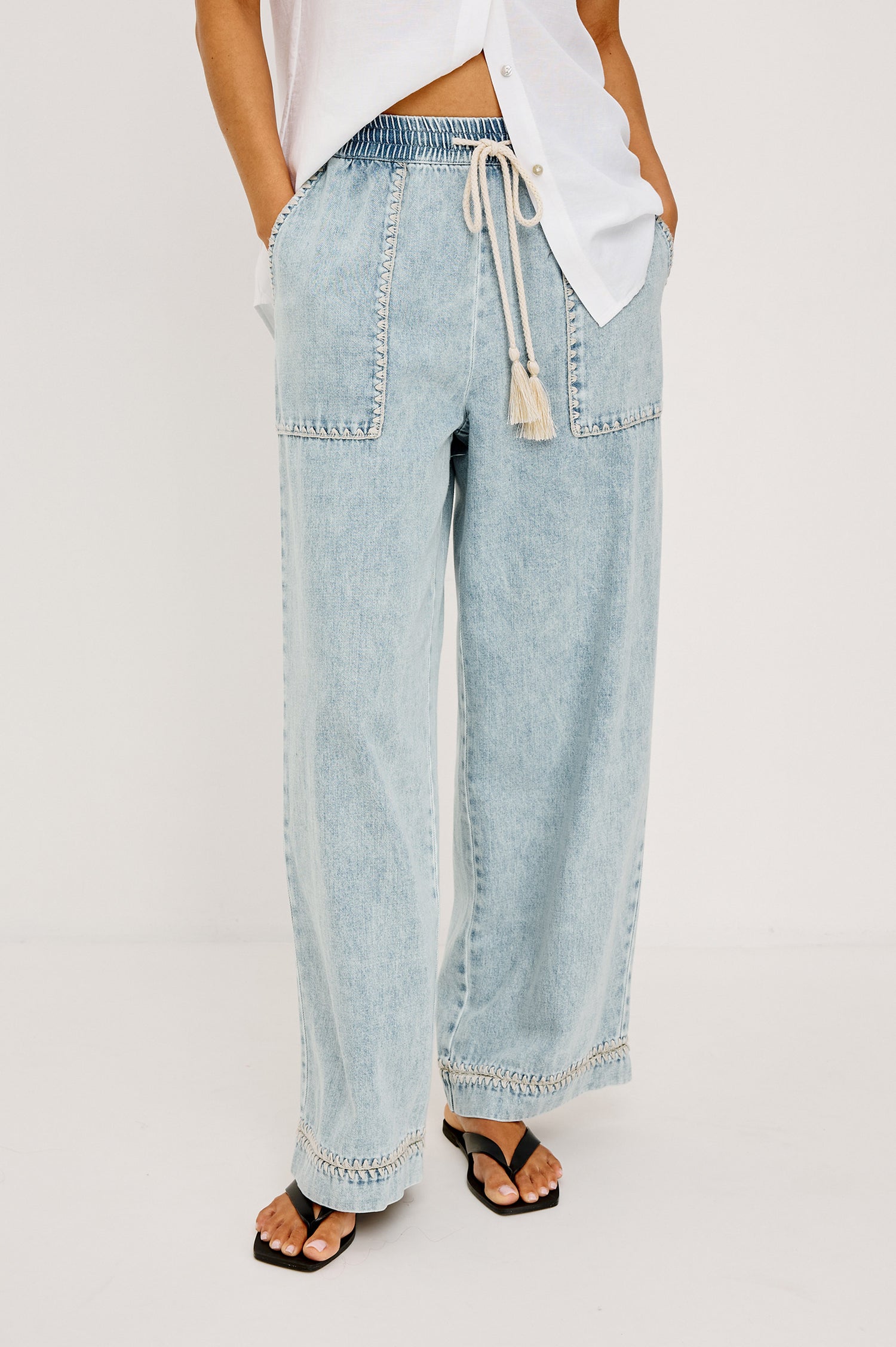 Campo Jean in Cotton Lyocell Denim With Blanket Stitching, Elastic Waist, Side Pockets, and Single Back Pocket in Indigo Blanket Stitch Colorway - Full Body Front View Featured on Model