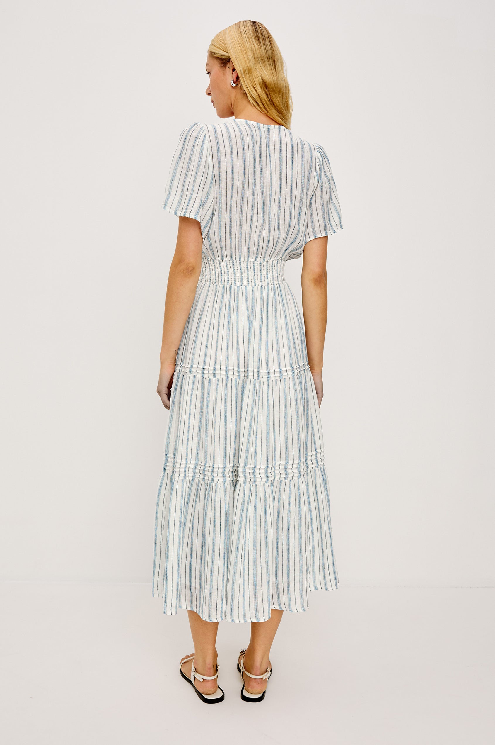 Cannes Midi in Linen With Half Placket Neckline Short Sleeves Smocked Waist and Tiered Skirt in Windward Stripe - Full Body Back View Featured on Model