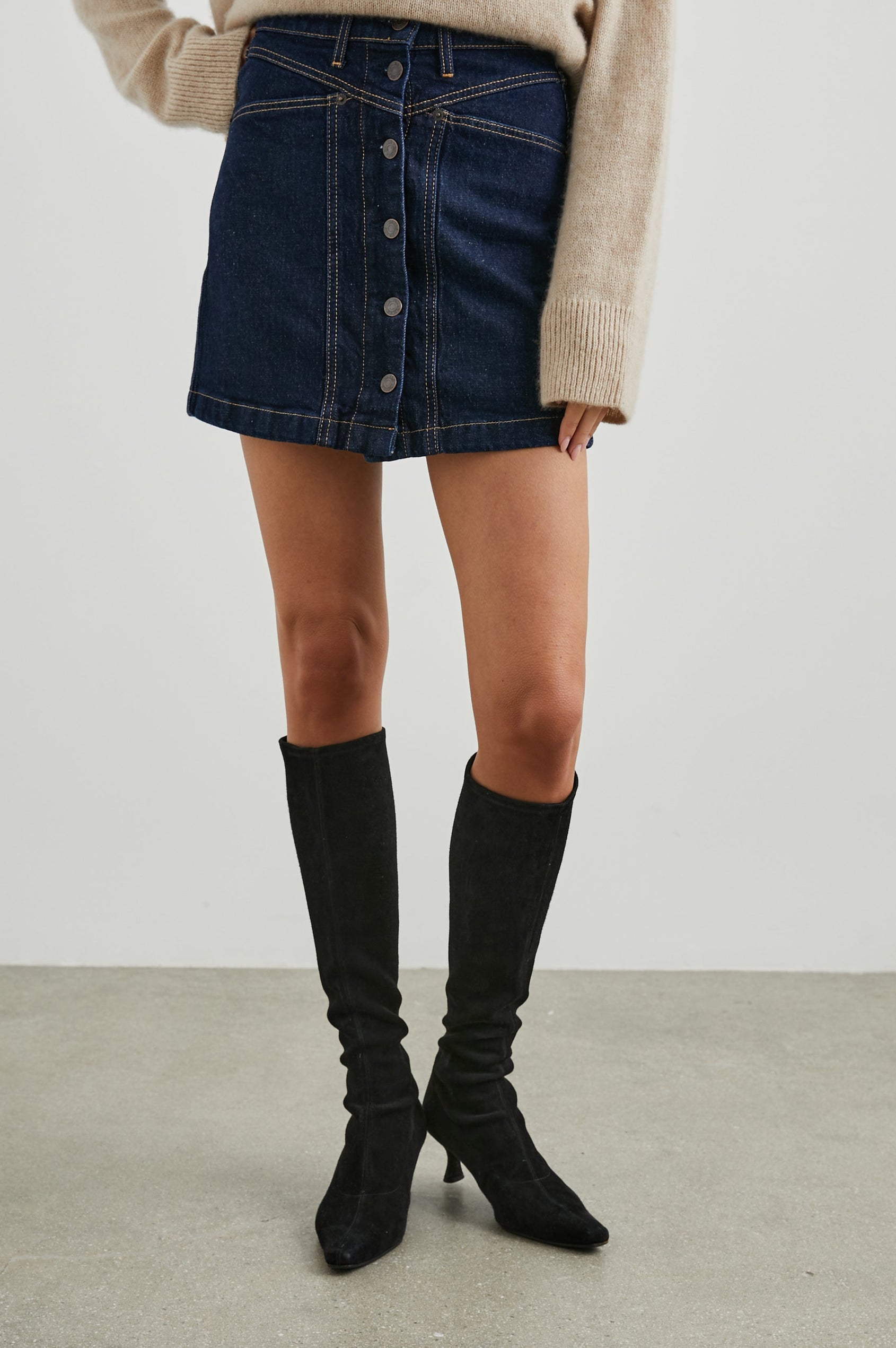 Canyon Denim Mini Skirt with a Full Button Front, Belt Loops, Two Front Pockets and Two Back Patch Pockets in Midnight Blues Colorway - Front View Featured on Model