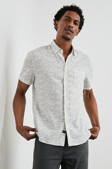 Carson Short Sleeve Button Up with a Chest Patch Pocket in Crop Circle White Colorway, Small Olive Leaves on White - Front View Featured on Model