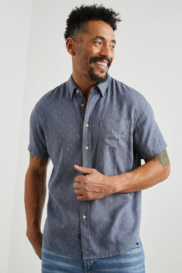 Carson Short Sleeve Button Up with a Chest Patch Pocket in Louis Leaf Slate Colorway, Small Tan and White Leaves on Slate- Front View Featured on Model