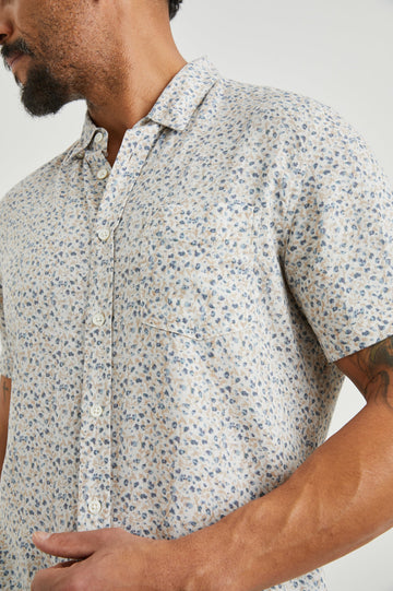 Carson Short Sleeve Button Up with a Chest Patch Pocket in Spring Blossom Parchment Colorway, Blossoms in Blue and Tan on Parchment - Front View Featured on Model