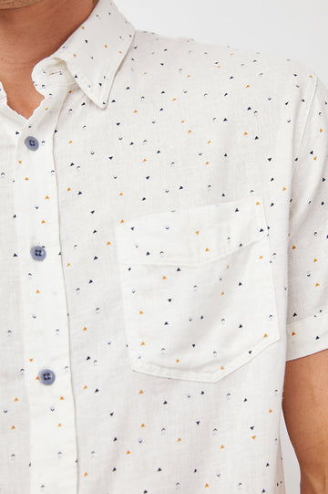 Carson Short Sleeve Button Up with a Chest Patch Pocket in Triangle Geo Colorway, Small Tan, Grey and Black Triangles on White - Front View Featured on Model