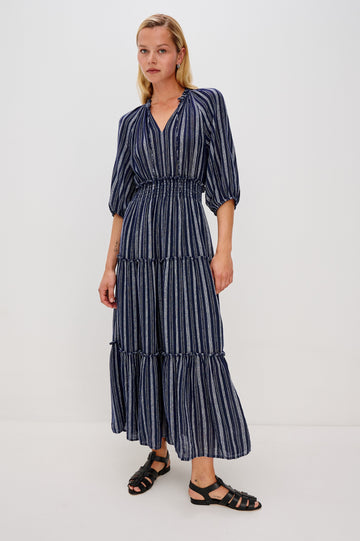 Caterine Maxi Dress with Mid-length Sleeves, a V neck, a Shirred Collar with a tie, a Smocked Waist, and a Tiered Skirt in Roche Stripe Colorway - full body front view on model