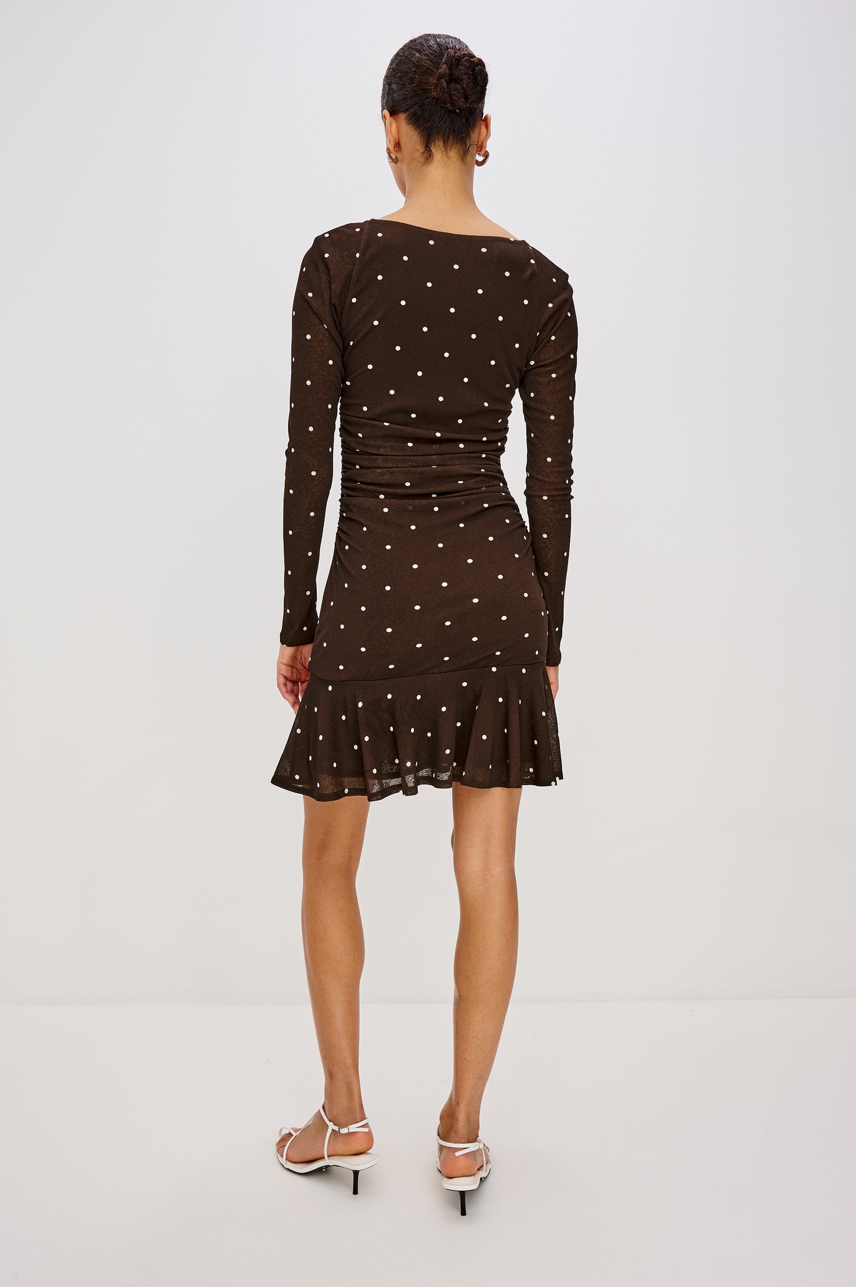 A cocoa-brown mesh midi dress with playful polka dots. The dress has an asymmetrical cowl neckline, long raglan sleeves, shirring at the waist, and a bias-cut skirt. Back View Featured on Model