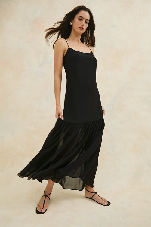 Chandra Maxi Tank Dress with Spaghetti Straps and a Contrast Semi Sheer Fabric Gathered Hem in Black Colorway. Full Body Front View Shown on Model.