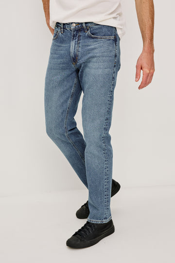Clayton Slim Straight is a Classic 5-Pocket Jean in Heritage Indigo Colorway, a Medium Blue Wash. Front View Featured on Model.