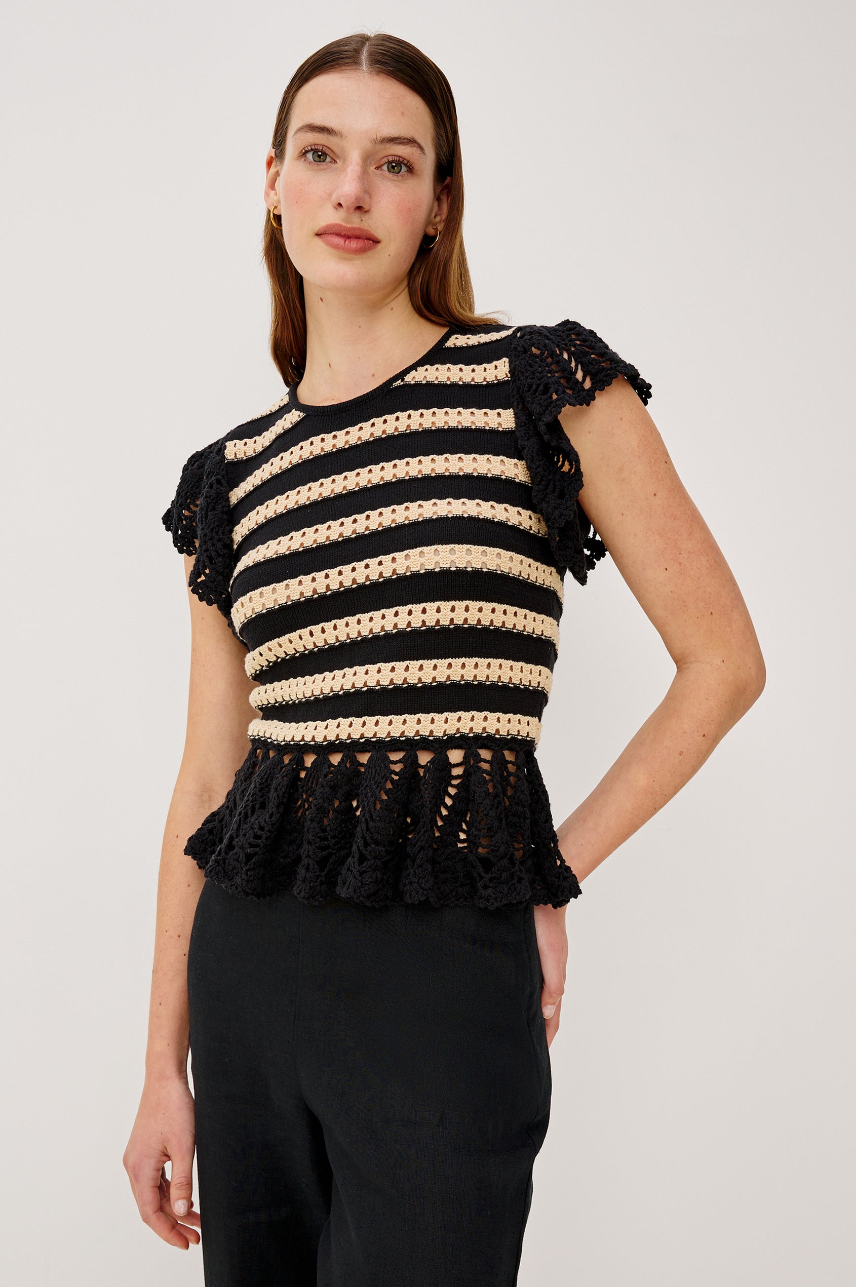 Coen Top in Cotton Blend Crochet With Crew Neckline Eyelet Detailing Flutter Sleeves Pepplum Hem and Back Keyhole With Adjustable Ties in Black Oat Stripe Colorway - Upper Body Front View Featured on Model