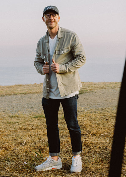 MALE WEARING KEROUAC SHIRT JACKET (LIGHT WEIGHT JACKET WITH WHITE BUTTON CLOSURE) IN COLOR NATURAL (TAN)