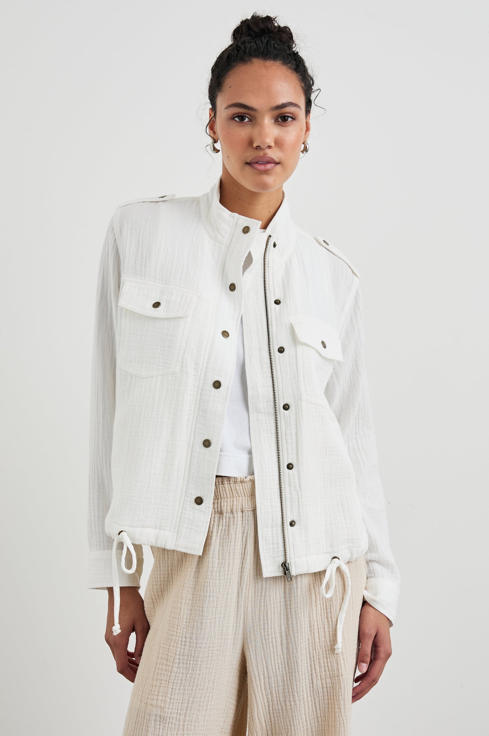 Collins Jacket with Zip and Snap Closure, Two Chest Snap Flap Pockets, Toggle Drawstring Hem, Snap Shoulder Straps and a Breathable Back Flap in Gauze White Colorway - Front View Featured on Model