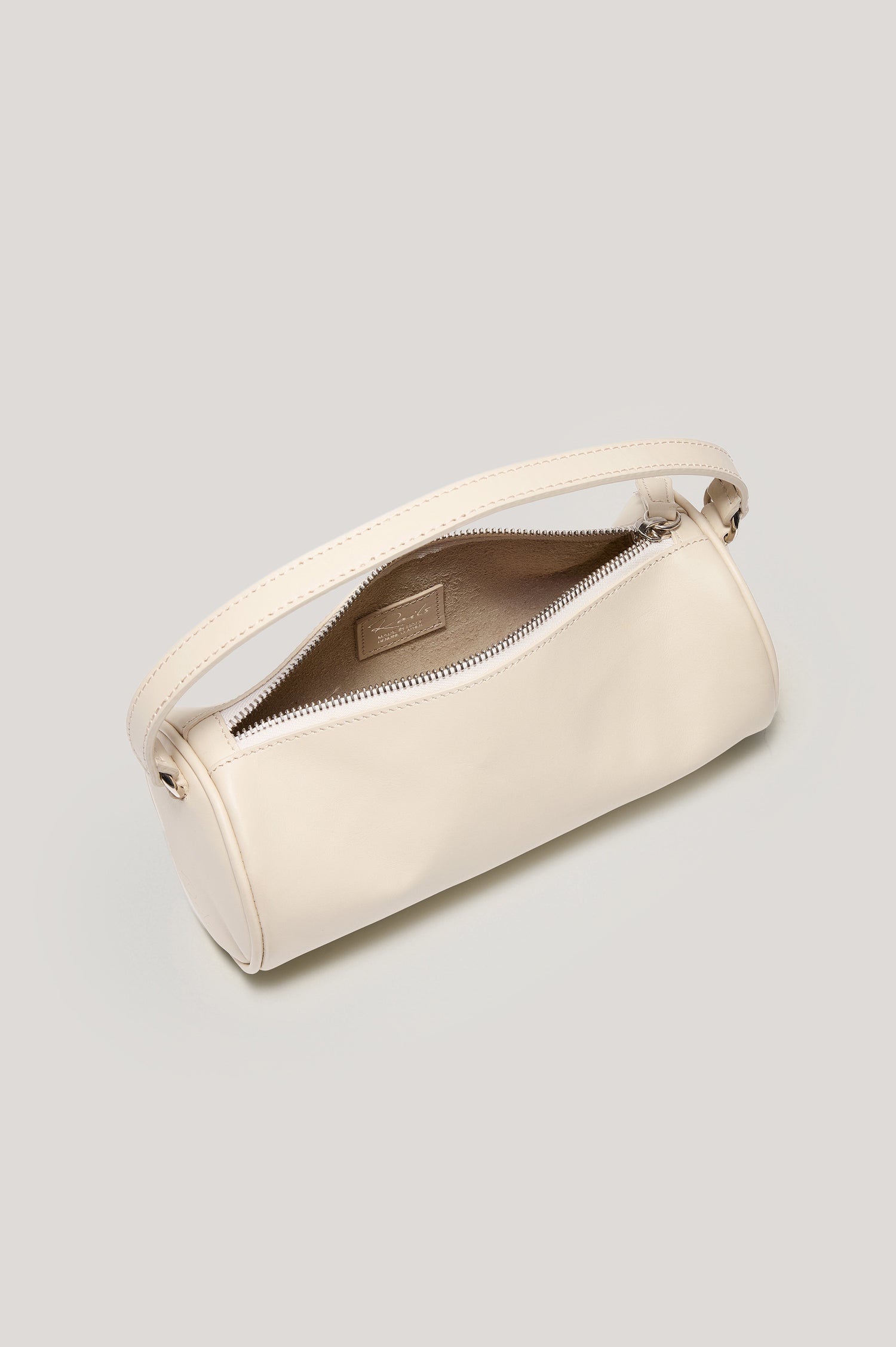 Como Mini Barrel Bag in Italian Leather With Fixed Top Strap, Removable and Adjustable Buckled Crossbody Strap, Top Zipper, Side-Embossed Logo, Branded Interior Label in Bone Colorway - Top View Featured