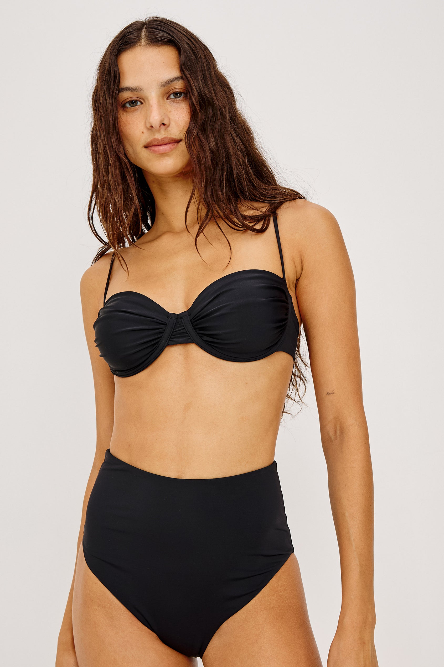 Concha Bikini Top With Balconette Shape, Ruched Underwire Bust Cups, Adjustable Shoulder Straps, and Back Hook Closure in Black Colorway - Upper Body Front View Featured on Model