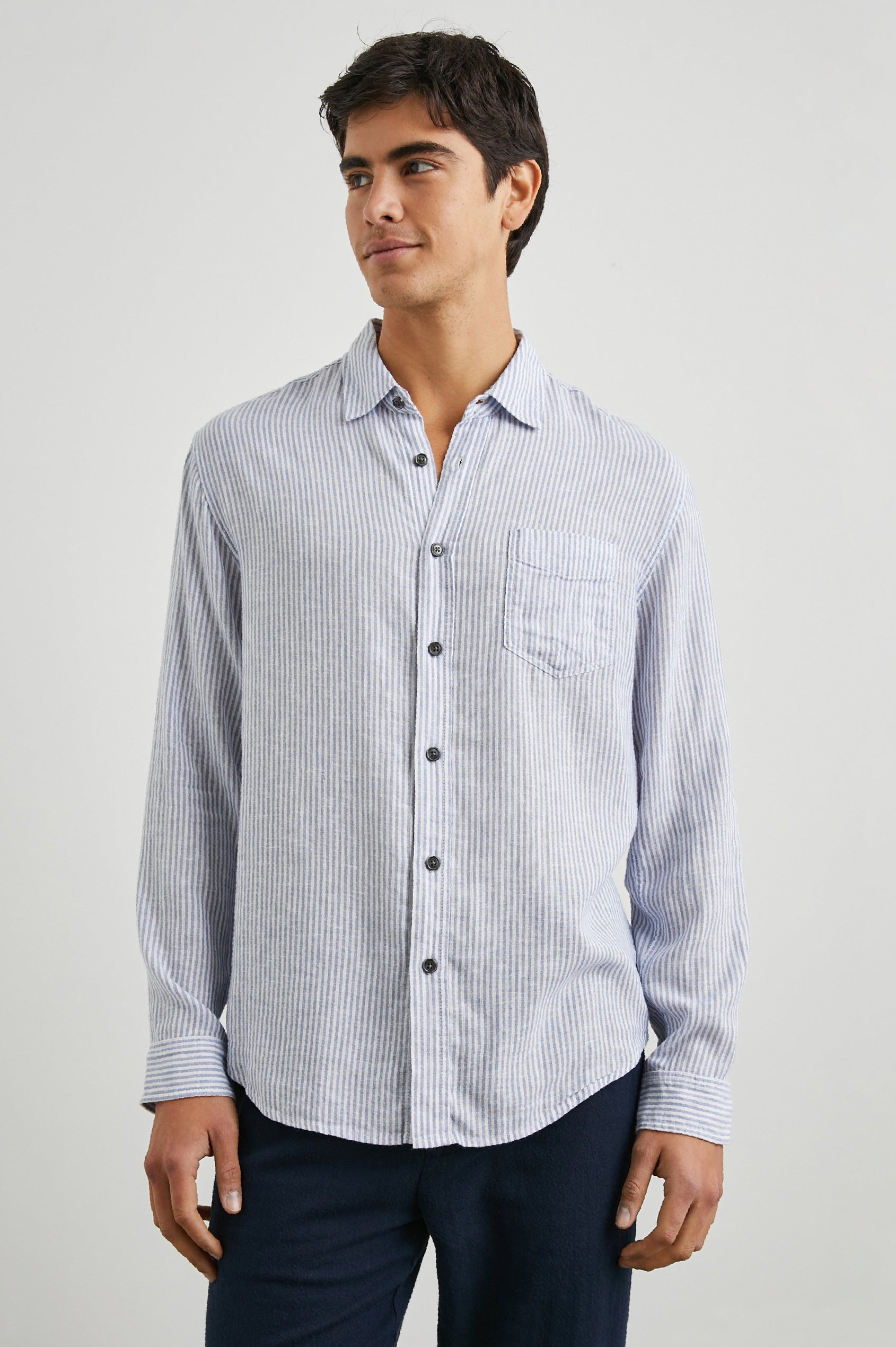 Connor Long-Sleeve Button Up with a Chest Patch Pocket in Denim White Railroad Colorway, Vertical Stripes - Front View Featured on Model