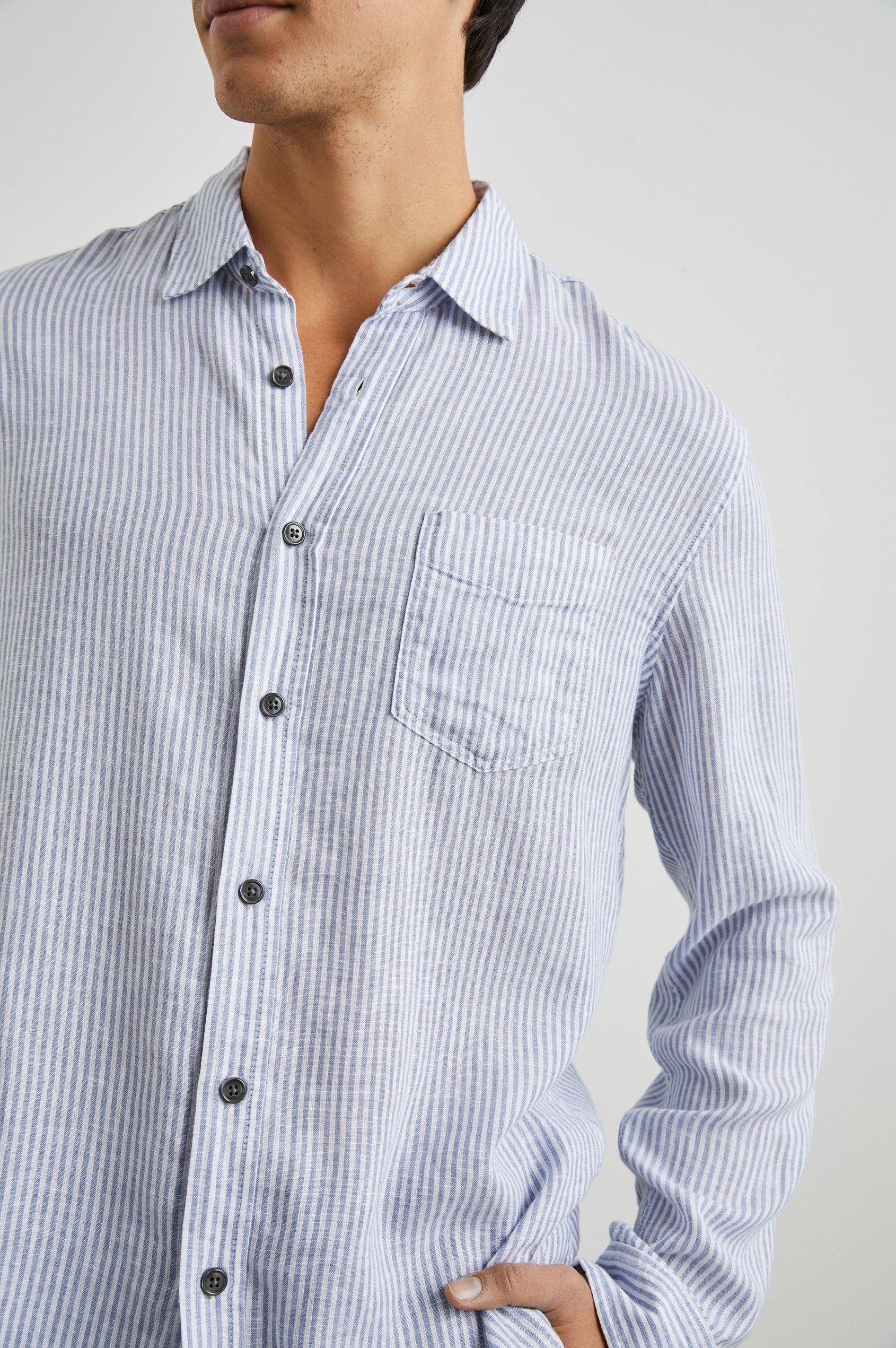 Connor Long-Sleeve Button Up with a Chest Patch Pocket in Denim White Railroad Colorway, Vertical Stripes - Front View Featured on Model