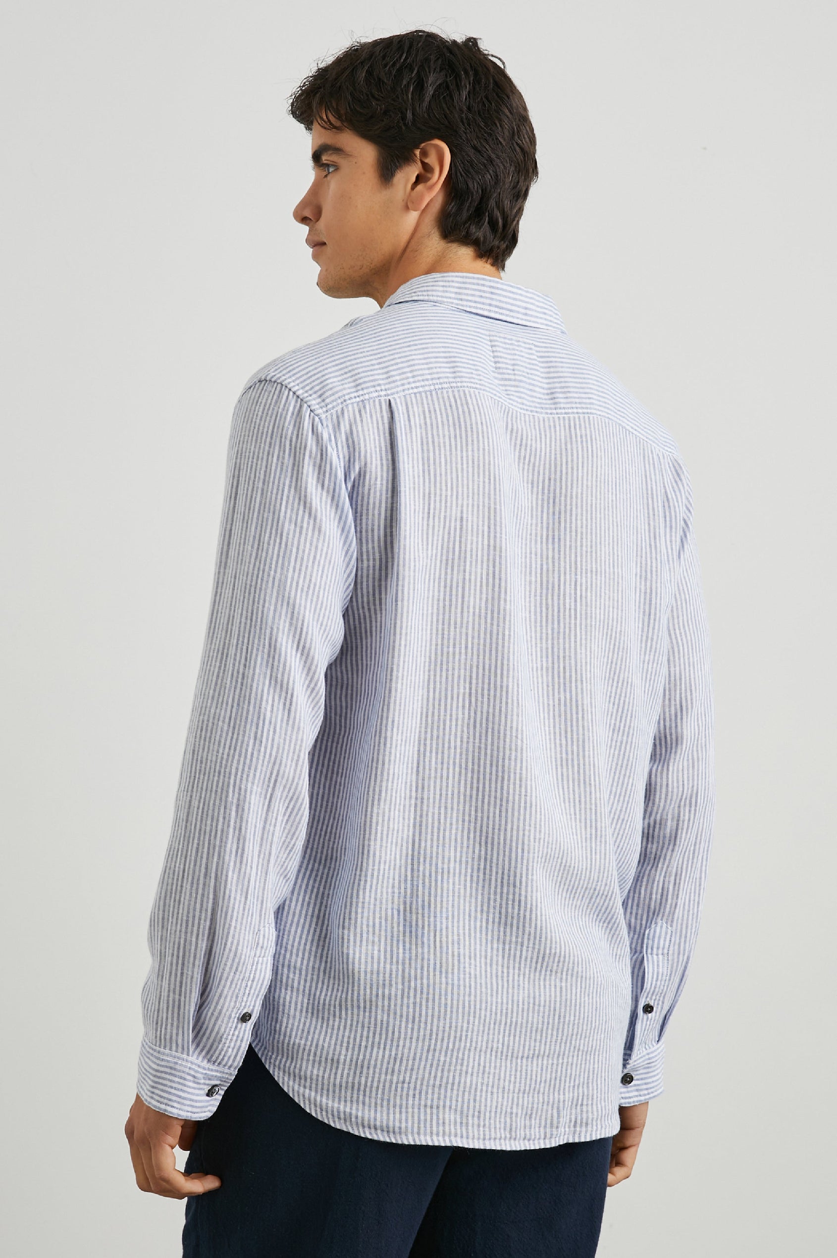 Connor Long-Sleeve Button Up with a Chest Patch Pocket in Denim White Railroad Colorway, Vertical Stripes - Back View Featured on Model