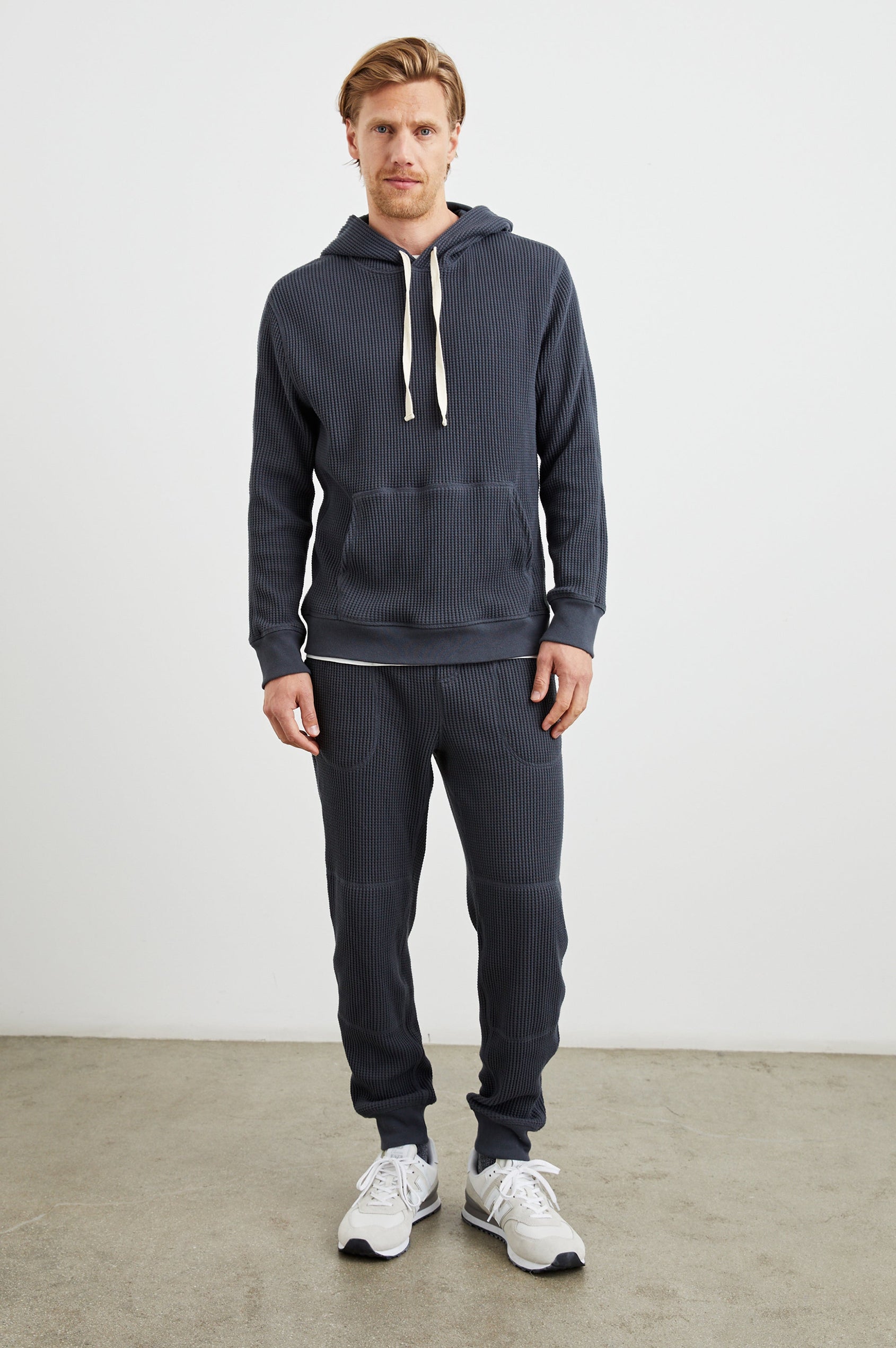Cooper Waffle Thermal Pants with an Elastic Drawstring Waist, Two Teardrop Front Pockets, Two Back Welt Pockets, Reinforced Knee Patches and Elastic Cuffs in Ink Colorway - Front Full Body View Featured on Model