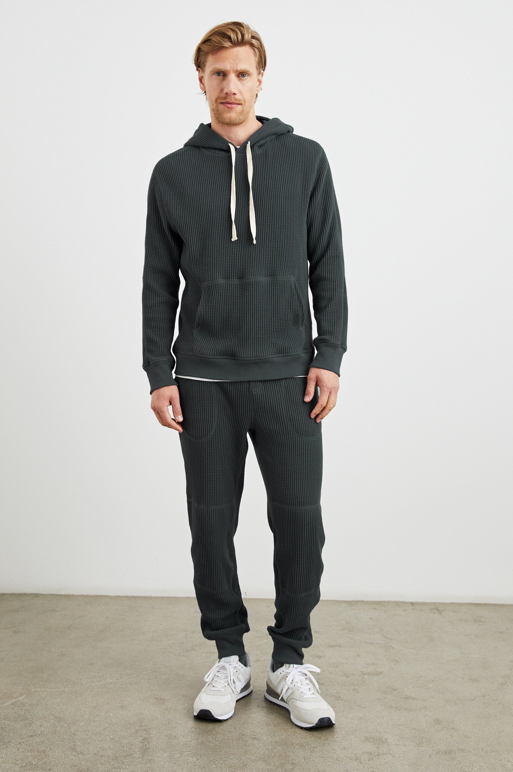 Cooper Waffle Thermal Pants with an Elastic Drawstring Waist, Two Teardrop Front Pockets, Two Back Welt Pockets, Reinforced Knee Patches and Elastic Cuffs in Ink Colorway - Front Full Body View Featured on Model