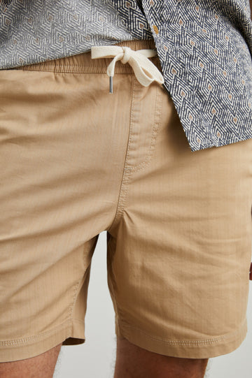 Cruz Shorts with a Drawstring Waist, Two Front Pockets, Two Back Button Flap Pockets in Khaki Colorway - Front View Featured on Model 