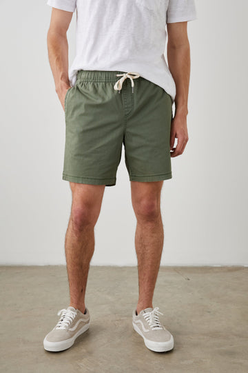 Cruz Shorts with a Drawstring Waist, Two Front Pockets, Two Back Button Flap Pockets in Spring Olive Colorway - Front View Featured on Model 