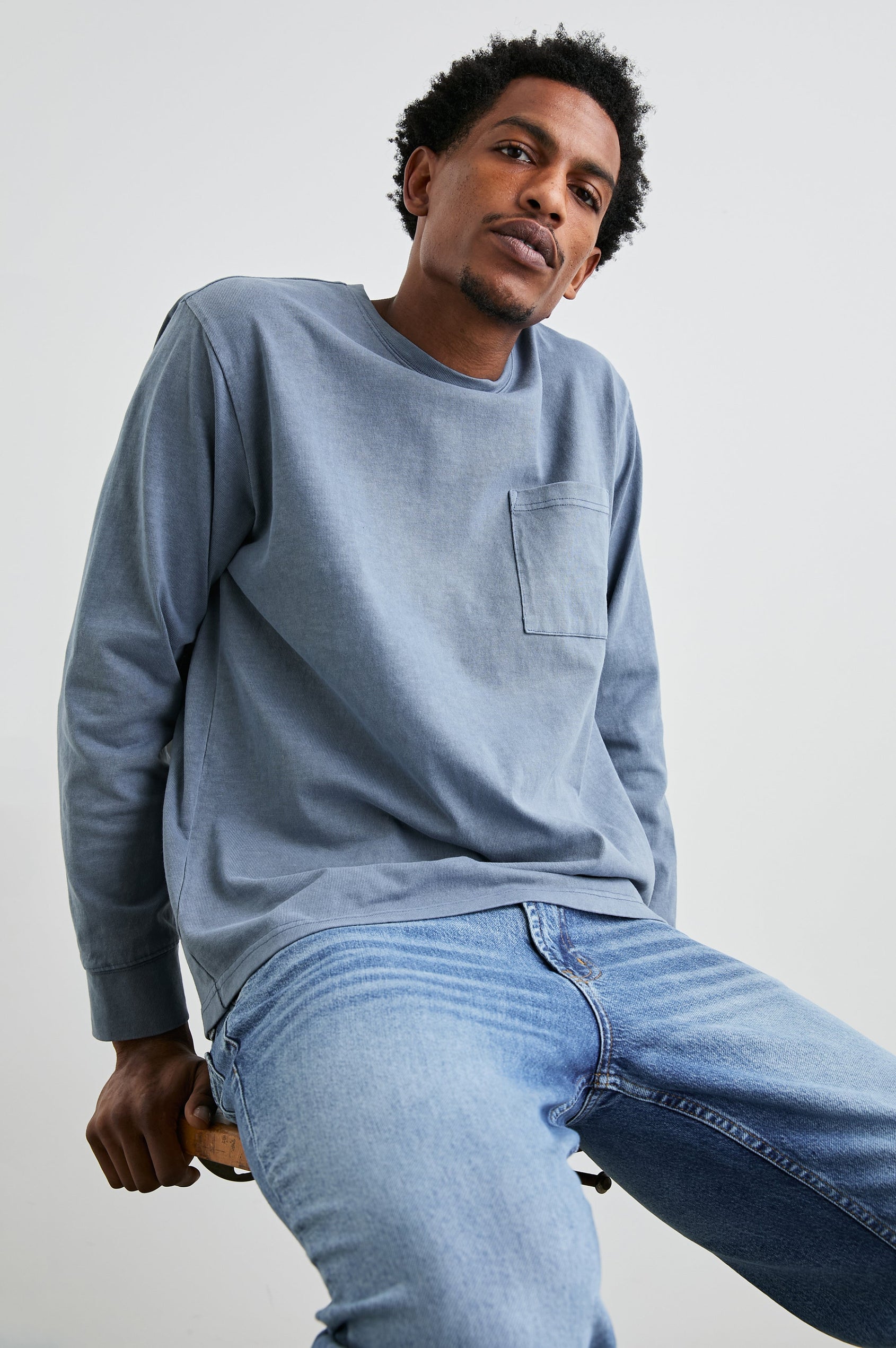 Cyd Long Sleeve Crew Neck T-Shirt  with a Chest Patch Pocket in Steel Colorway - Front View Featured on Seated Model