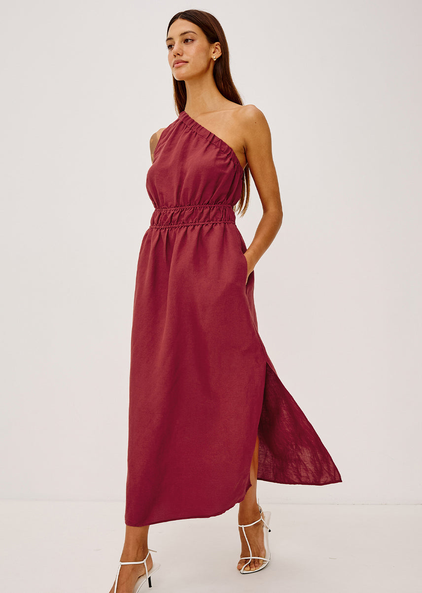 Woman wearing a burgundy one-shoulder dress on a white background
