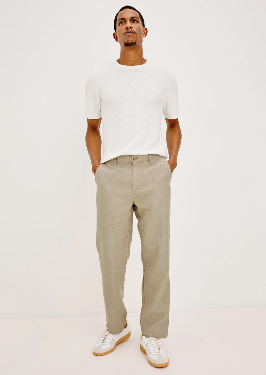 Man wearing a white shirt and beige pants 