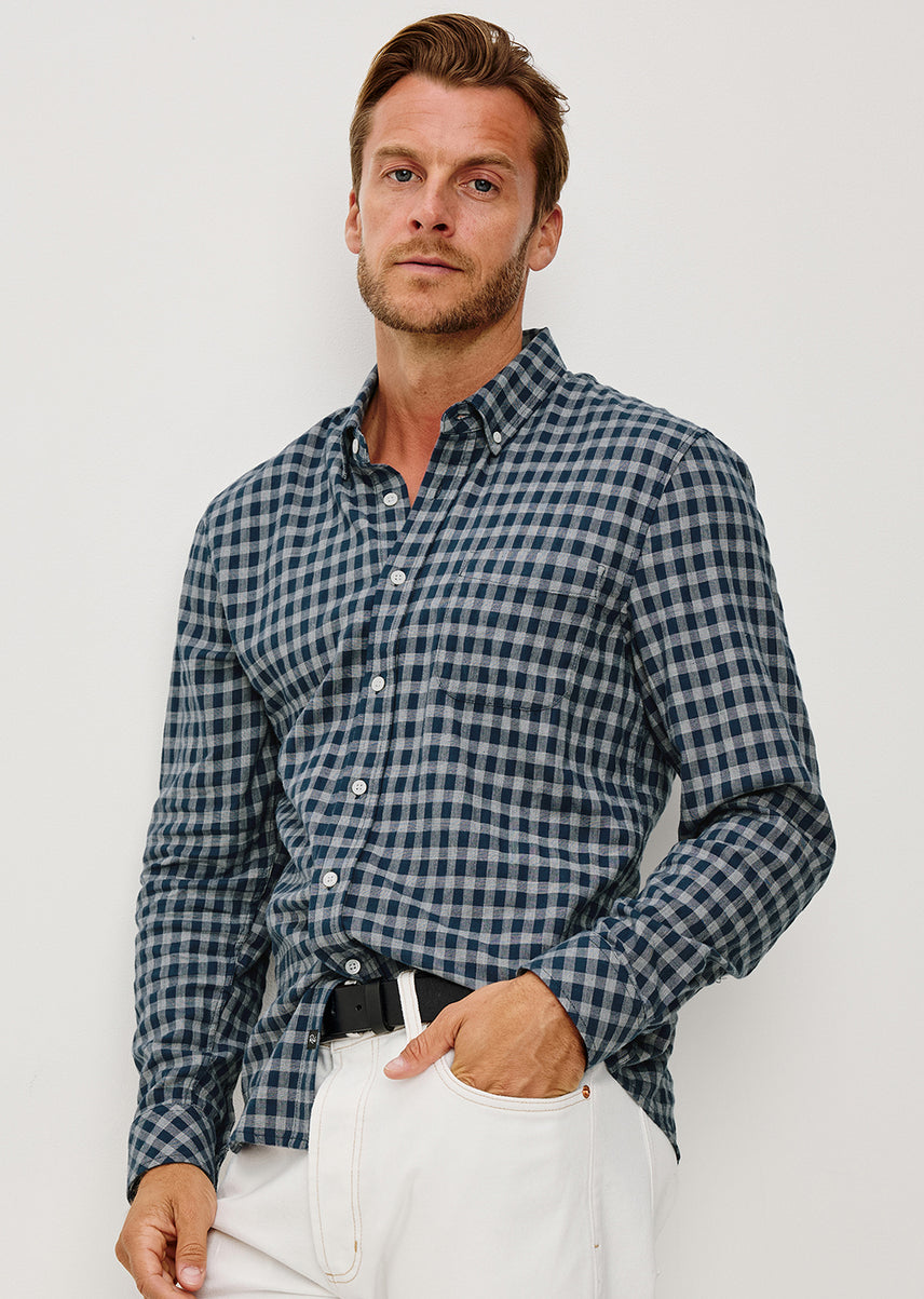 Man wearing a blue and white checkered shirt against a white background