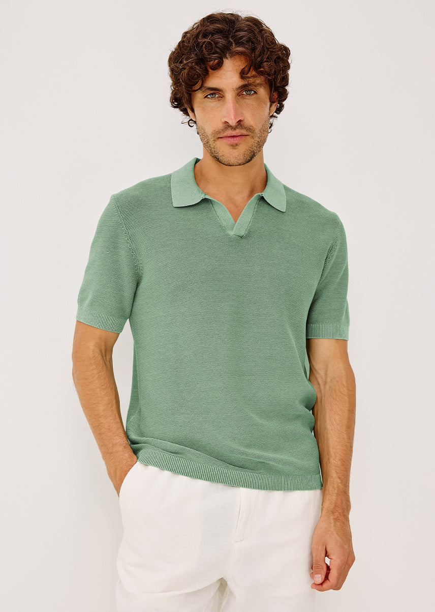 Man wearing a green shirt and white pants