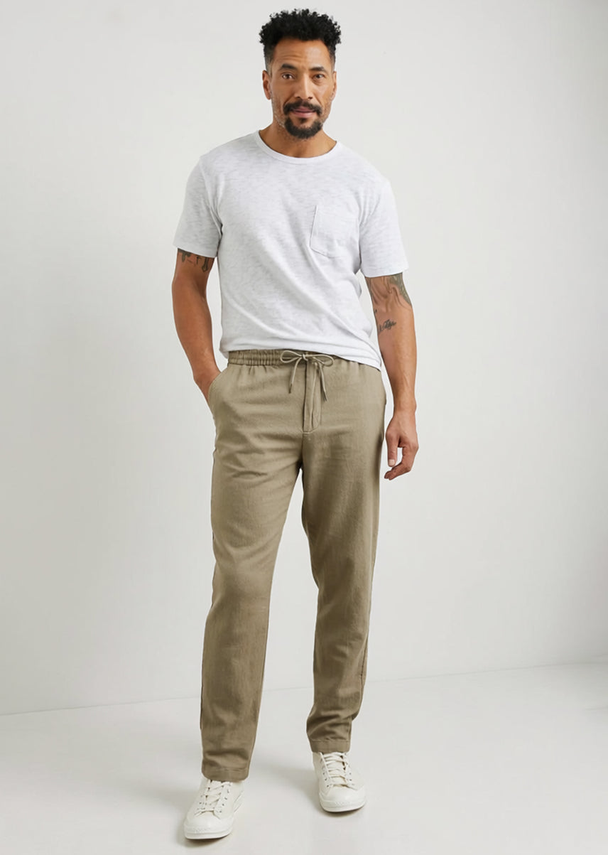 Man wearing a white t-shirt and beige pants on a white background
