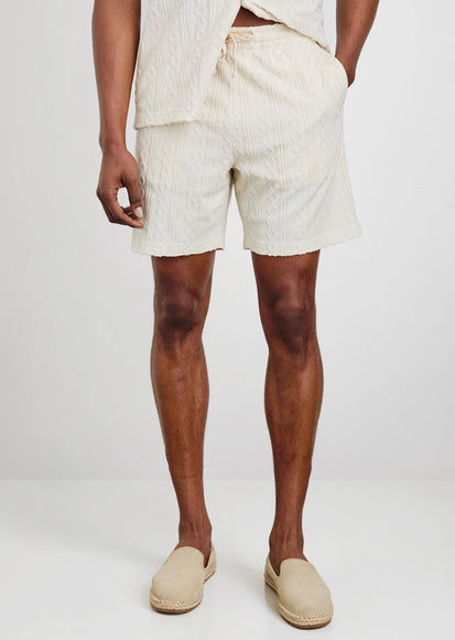 Man wearing light-colored shorts and shoes on a white background