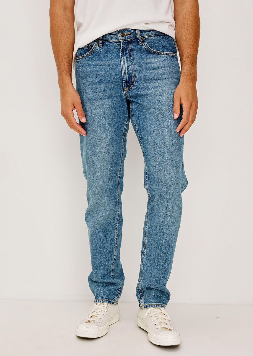 Man wearing a white shirt with blue jeans 