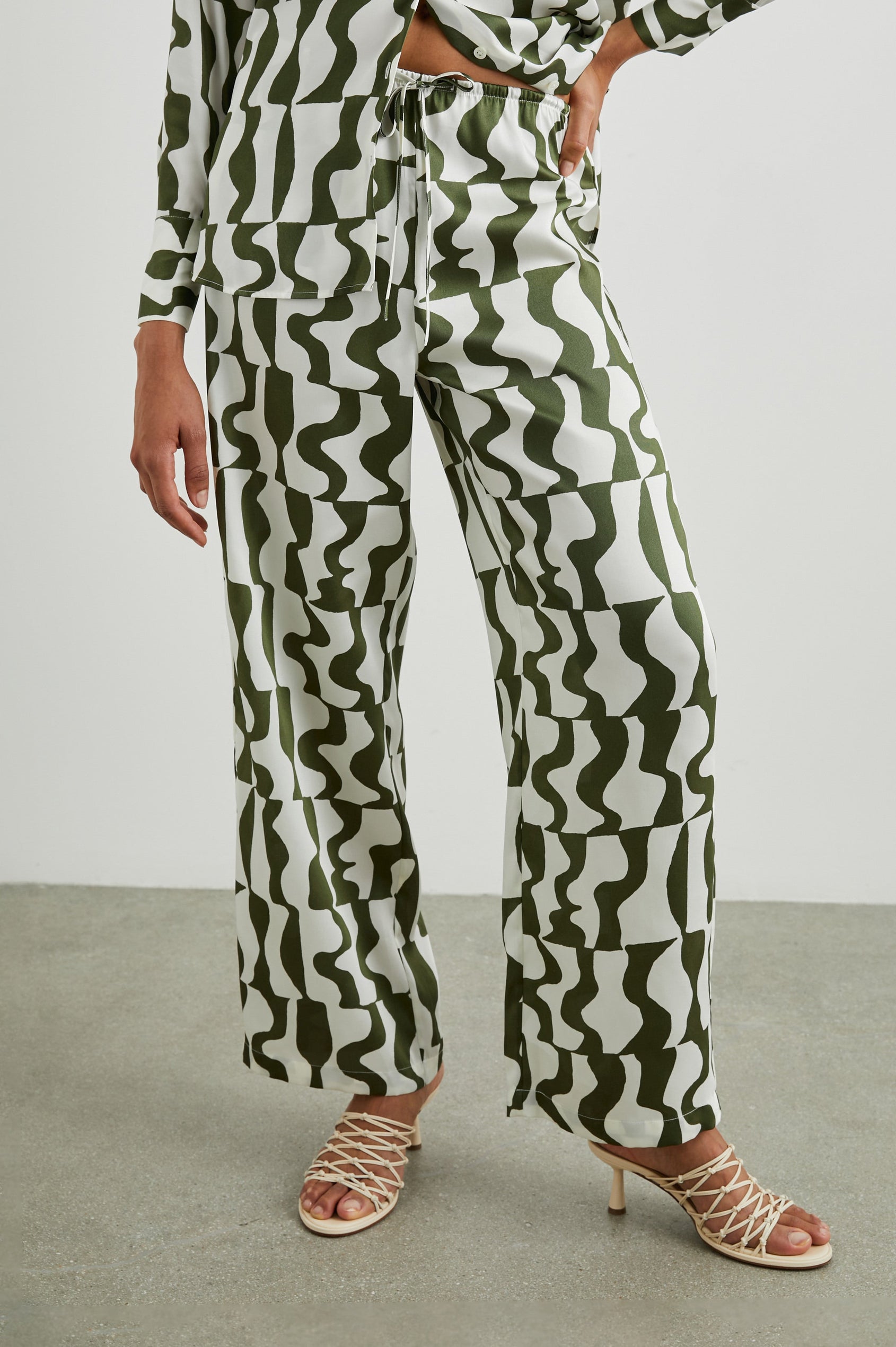 Damini Pants with a Drawstring Waist and Two Front Pockets in Noto Colorway, an olive and white pattern - Front View Featured on Model