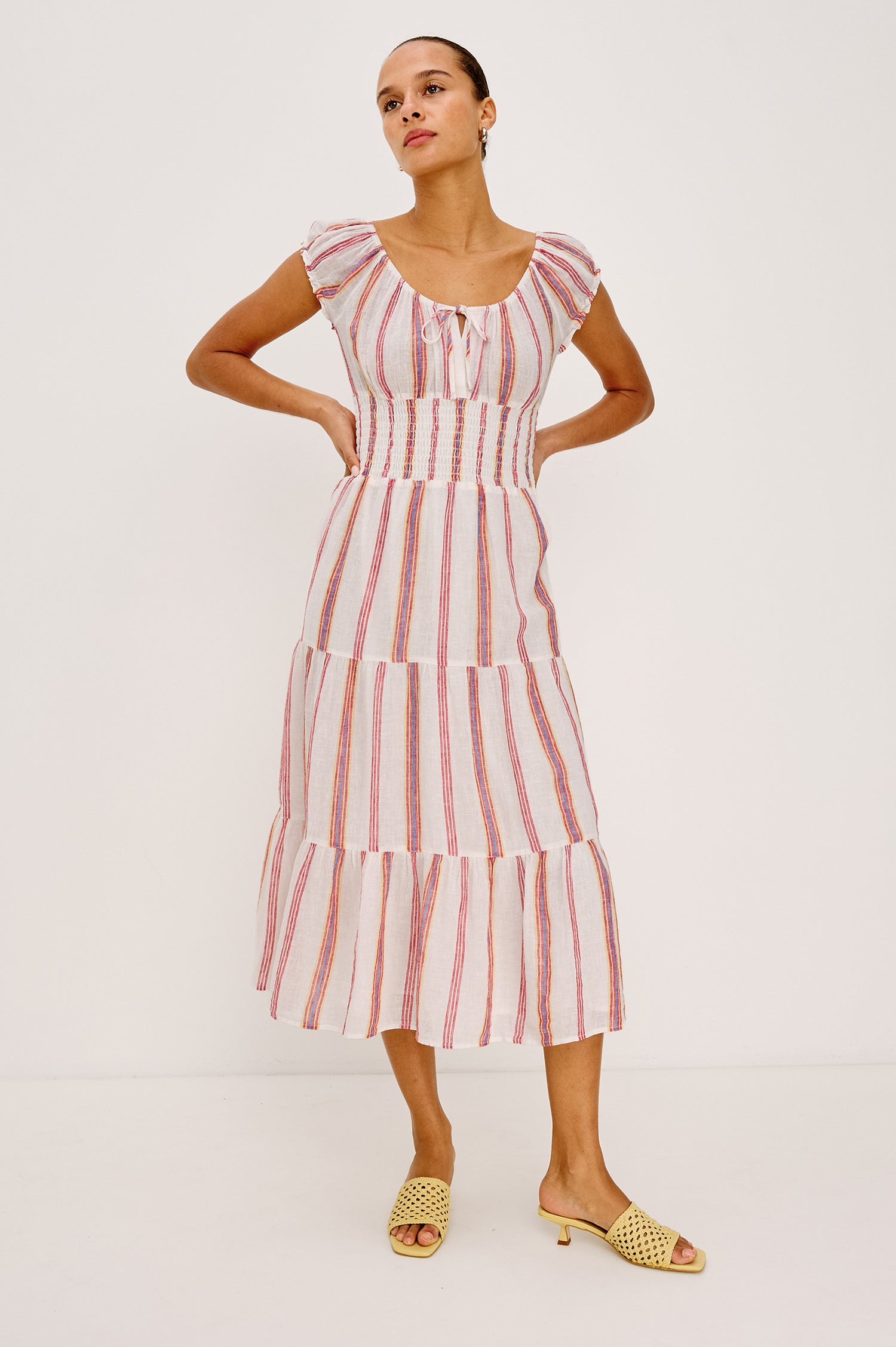 Daria Dress in Luxe Linen With Cap Sleeves, Scoop Neckline, Bust Ties, Smocked Waist, and Tiered Skirt in Primavera Stripe Colorway - Full Body Front View Featured on Model