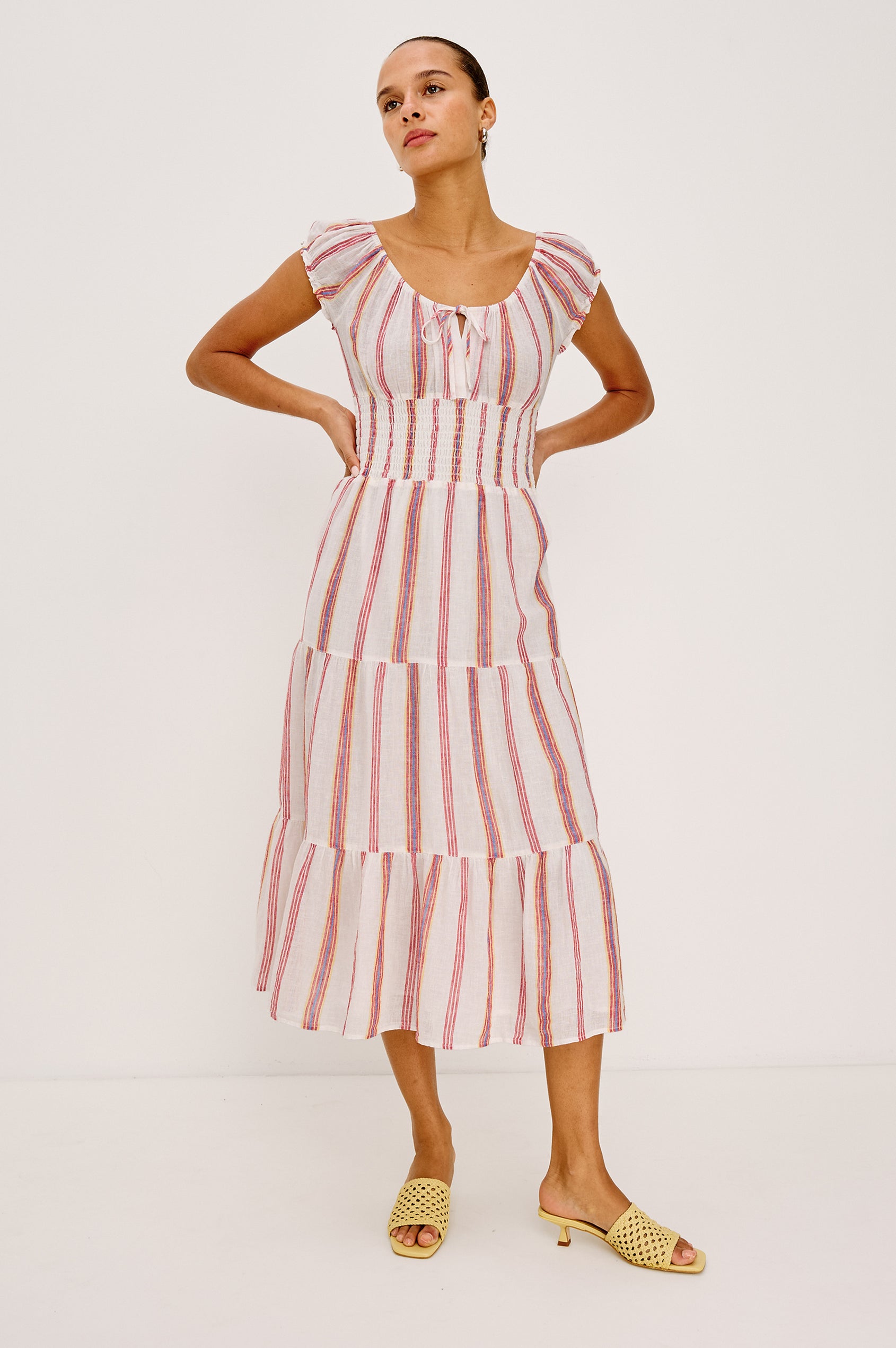 Daria Dress in Luxe Linen With Cap Sleeves, Scoop Neckline, Bust Ties, Smocked Waist, and Tiered Skirt in Primavera Stripe Colorway - Full Body Front View Featured on Model