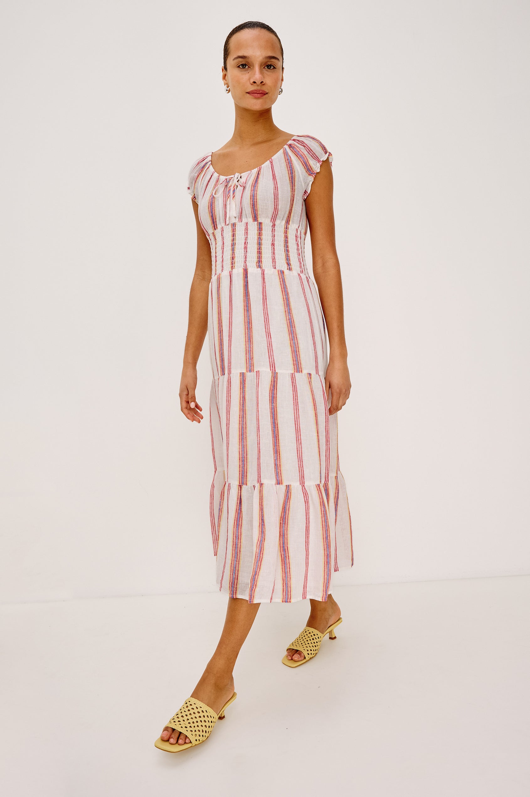 Daria Dress in Luxe Linen With Cap Sleeves, Scoop Neckline, Bust Ties, Smocked Waist, and Tiered Skirt in Primavera Stripe Colorway - Full Body Front View Featured on Model