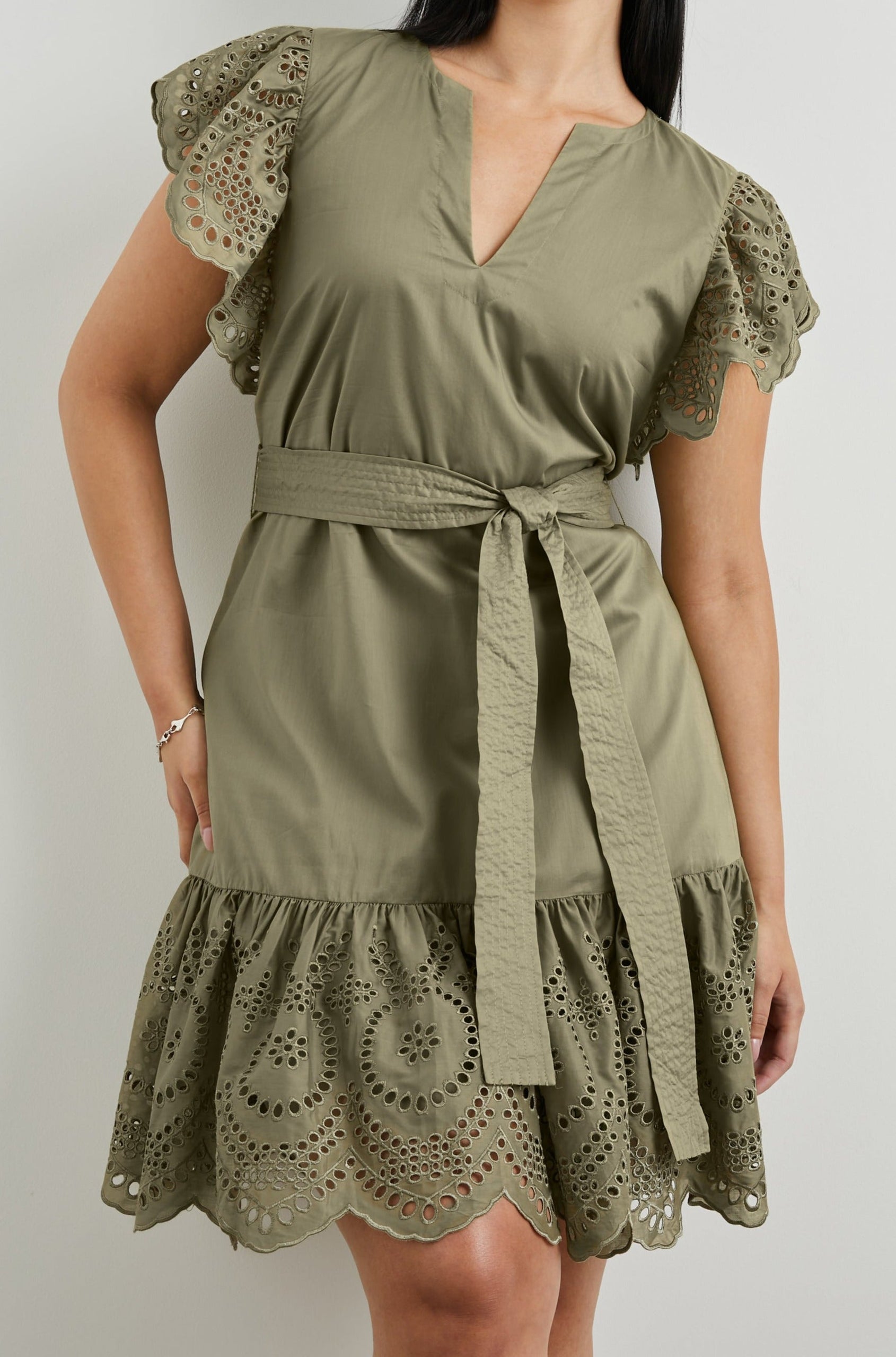 Darlene Short Sleeve, Above-The-Knee Dress with Flutter Sleeves, a V Neck, Adjustable Waist Tie and an Eyelet Design on the Sleeves and Hem in Canteen Colorway - Front View Featured on Model 