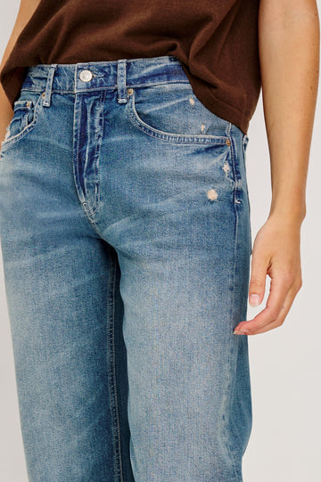 Del Mar low slung baggy boyfriend 5-pocket jean in medium wash Tinted Indigo Destroy, with light destruction near front pockets - front detail view featured on model.