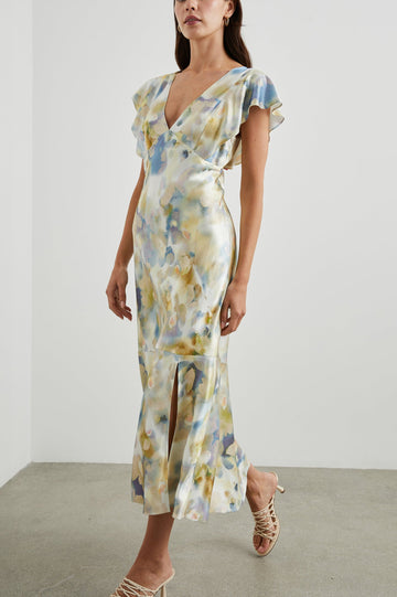 Dina Short-Sleeve Midi Dress with a Deep V Neck, Flutter Sleeves, and a Thigh Side Slit in Diffused Blossom Colorway, Flowers in Gold and Creams on Blue - Front Full Body View Featured on Model