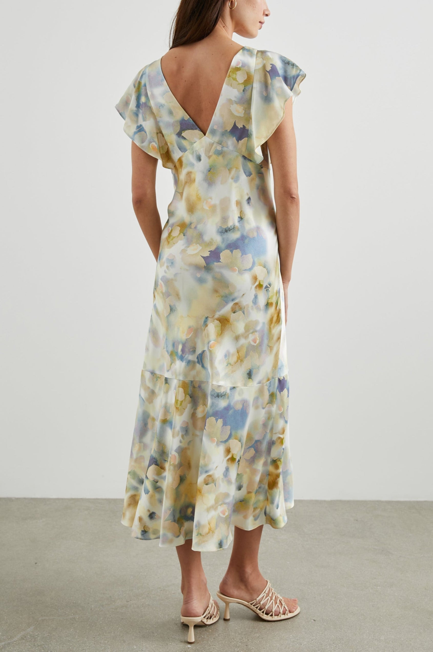 Dina Short-Sleeve Midi Dress with a Deep V Neck, Flutter Sleeves, and a Thigh Side Slit in Diffused Blossom Colorway, Flowers in Gold and Creams on Blue - Front Back Body View Featured on Model