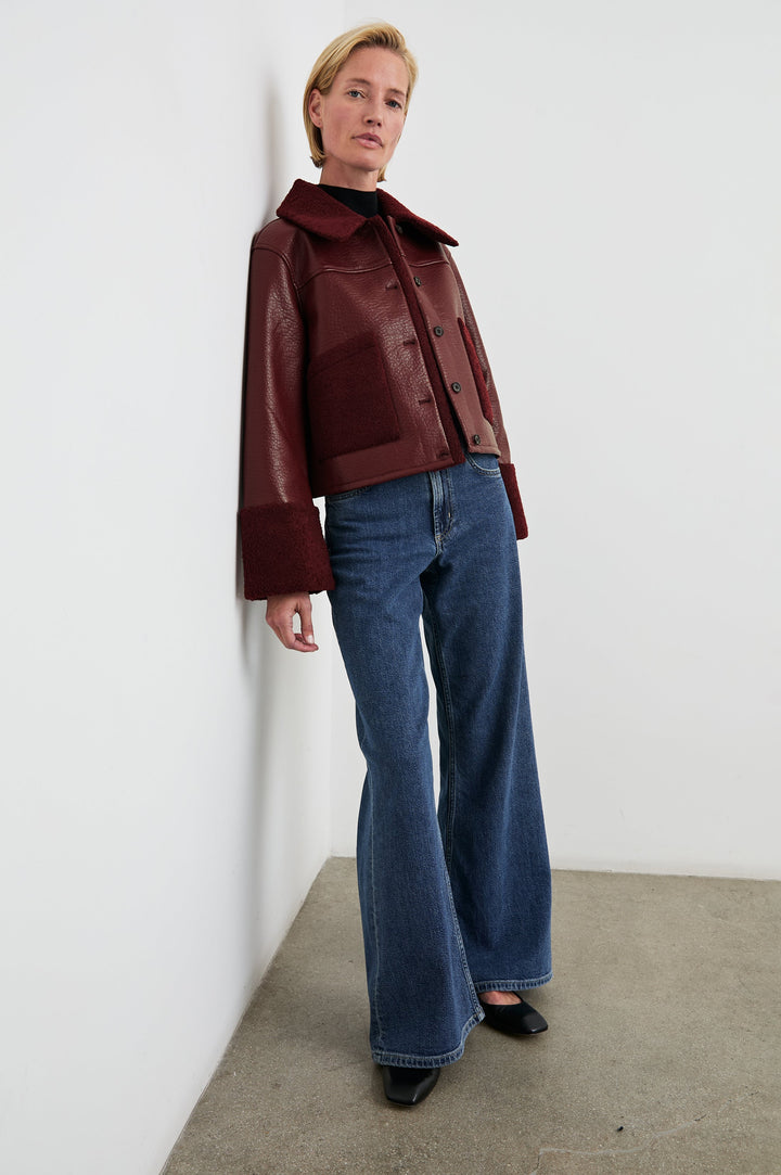 Dria Jacket with Button Closure, Two Front Patch Pockets and Faux Shearling at the Pockets, Cuffs, Collar and Opening in Maroon Shearling Colorway, Front Full Body View Featured on Model 