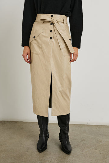 Edem Midi Skirt with a Tie Belt, a Center Slit, Four Button Closure at the Waist, Two Front Pockets Each Overlaid with a Button Flap Pocket and Two Back Welt Pockets in Dune Colorway, with Dark Brown Buttons - Front View Featured on Model