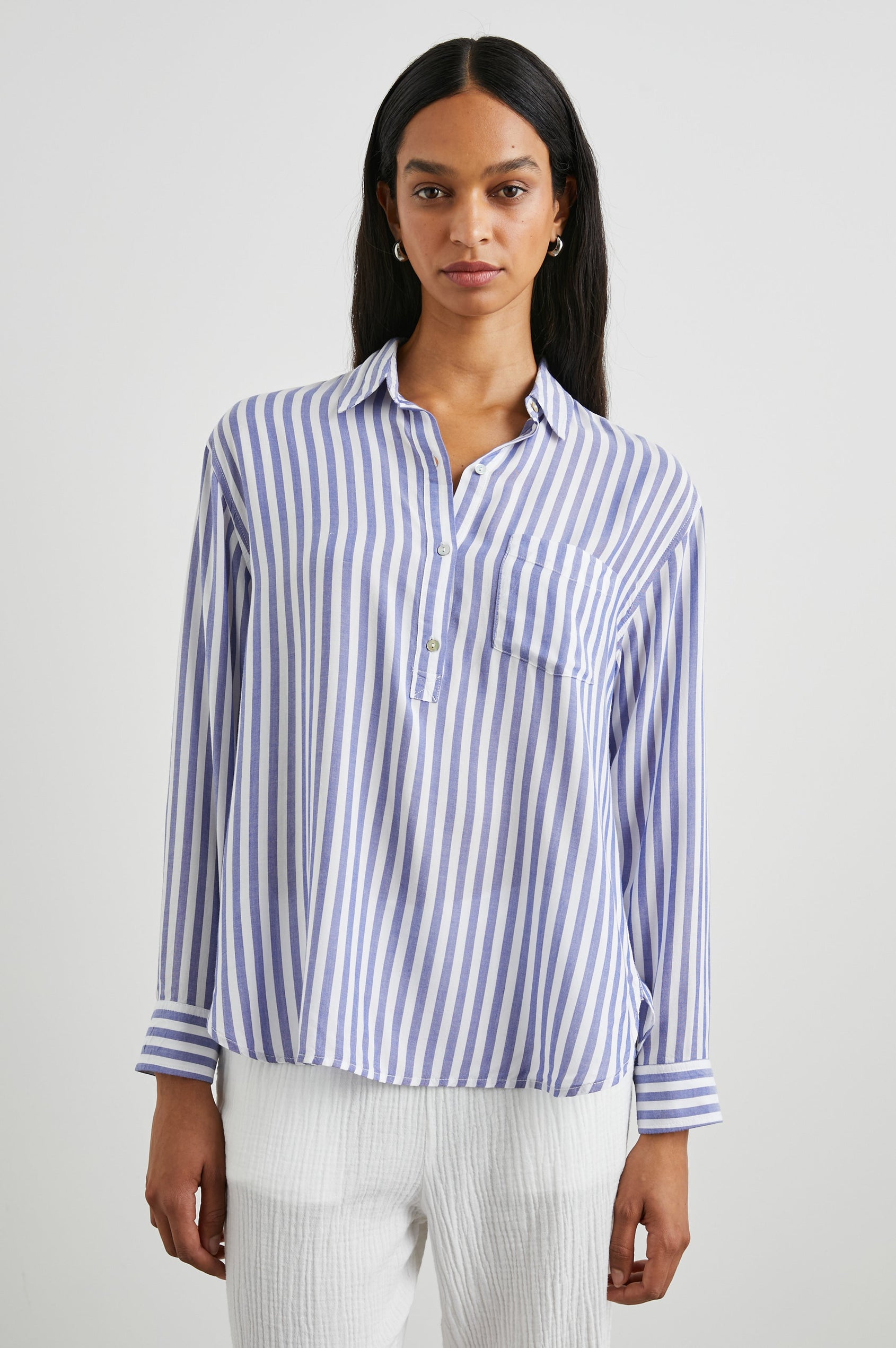 Elle Long Sleeve Shirt with a Four Button Placket, Buttoned Cuffs, a Chest Pocket and a Collar in Blue White Stripe Colorway, Vertical Stripes - Front View Featured on Model