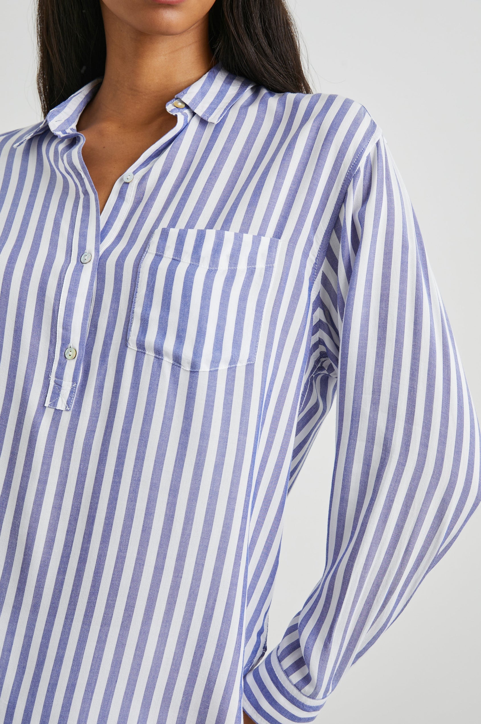 Elle Long Sleeve Shirt with a Four Button Placket, Buttoned Cuffs, a Chest Pocket and a Collar in Blue White Stripe Colorway, Vertical Stripes - Front View Featured on Model