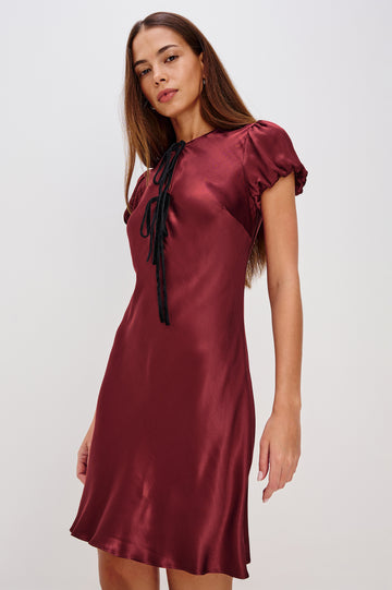 Elyssa Mini Dress in Satin Back Crepe With Bias Cut, Short Puff Sleeves, and Deep V-Neckline With Velvet Bow Self-Ties in Garnet Colorway - Full Body Front View Featured on Model