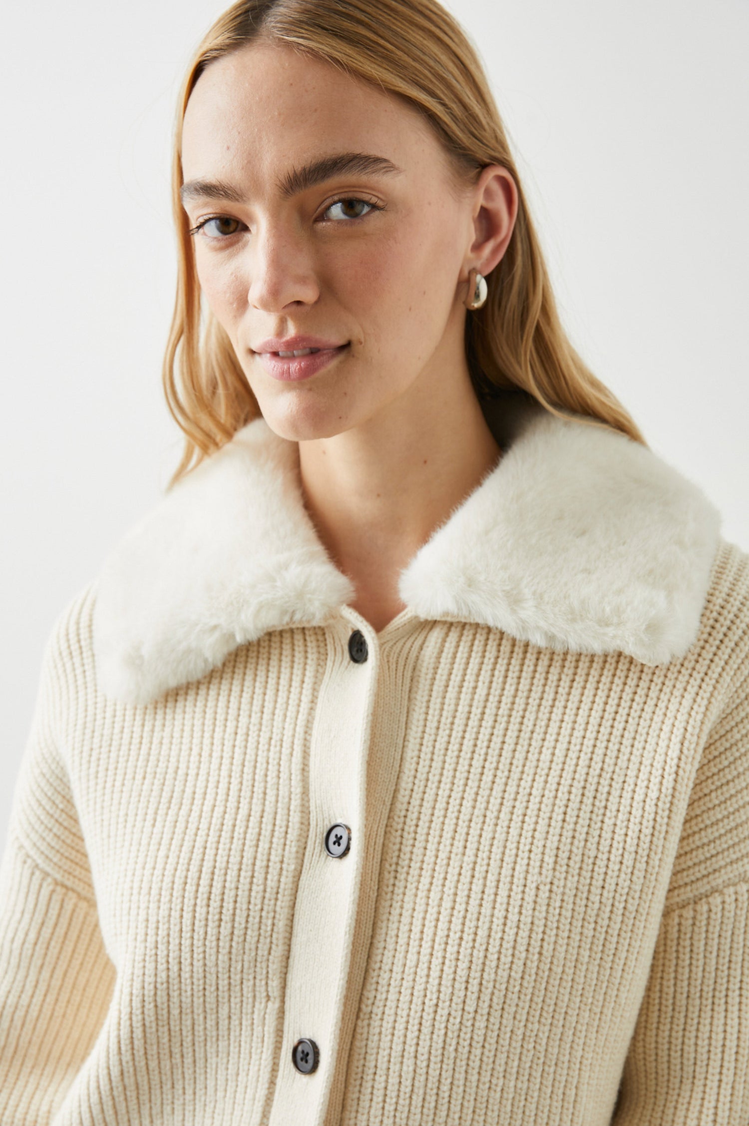 Esme Long-Sleeve Ribbed Sweater with Front Button Closure and a Faux Fur Collar in Ivory Colorway - Front View Featured on Model 