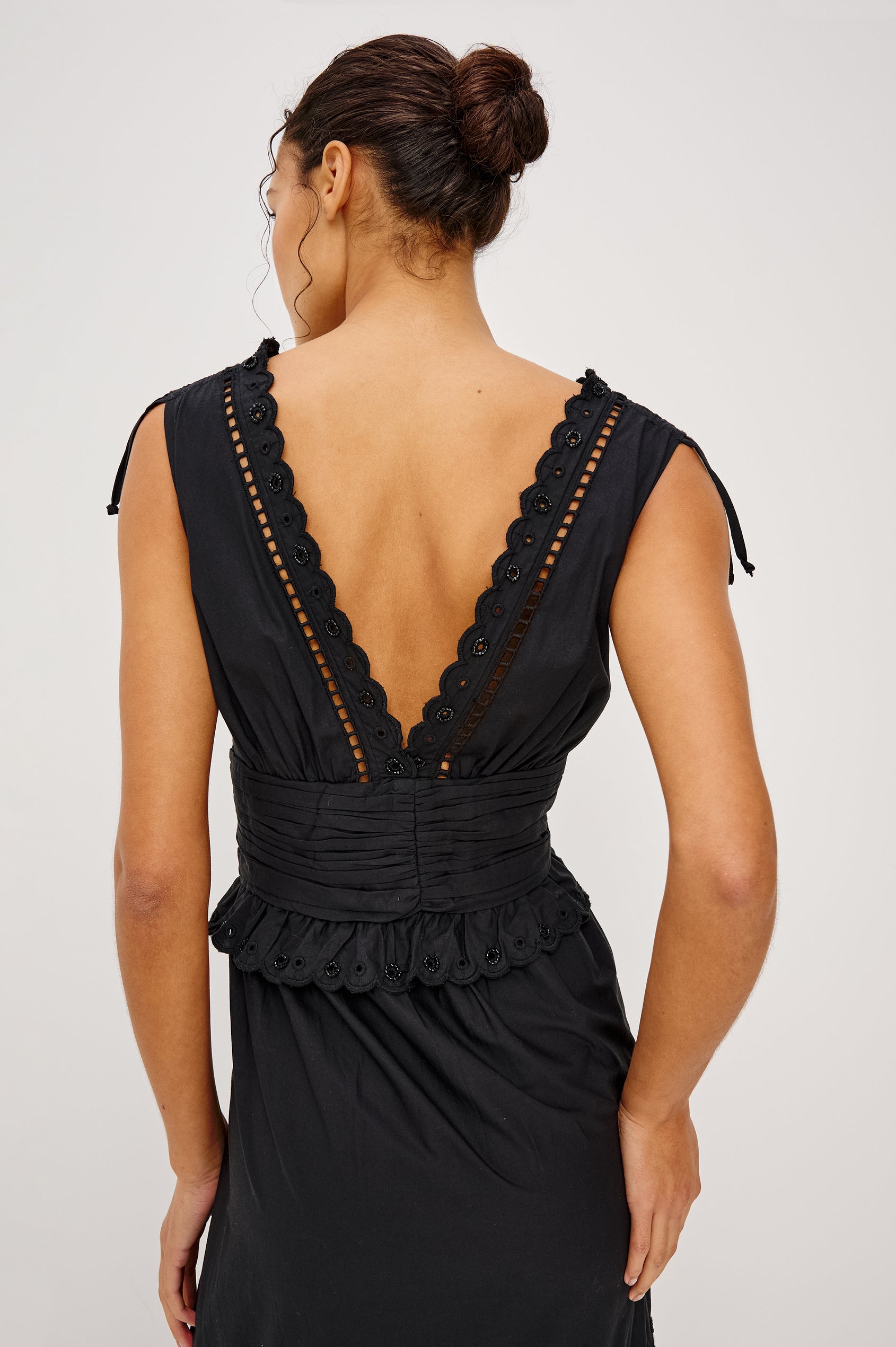 Esmeralda maxi dress has a plunging v-neckline, tiered skirt and intricate beading details in black colorway. Full body front view featured on model.