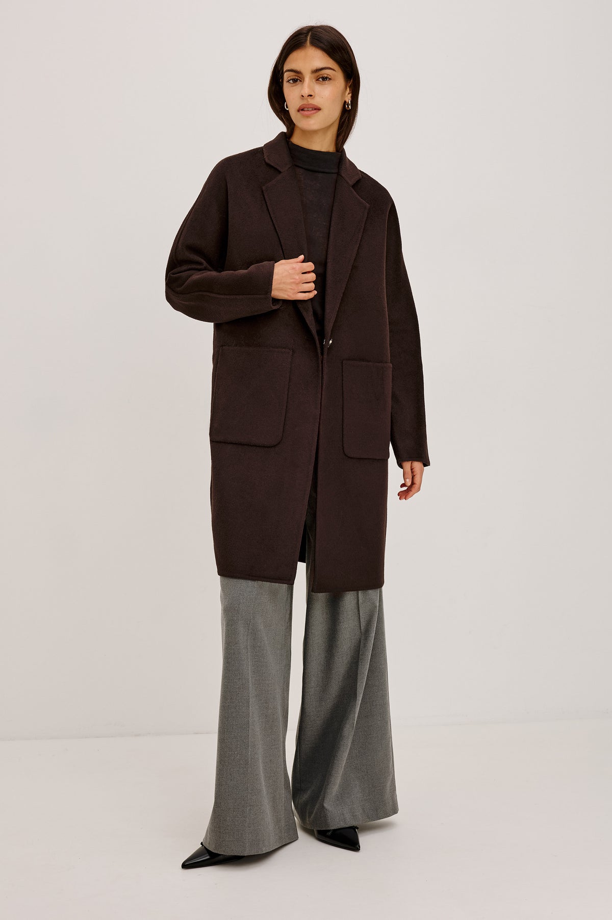 Everest Coat in Heavy Wool Blend With Longline Cut, Slightly Oversized Relaxed Fit, Lapel Collar, Single-Button Front, and Front Patch Pockets in Chocolate Colorway - Full Body Front View Featured on Model.